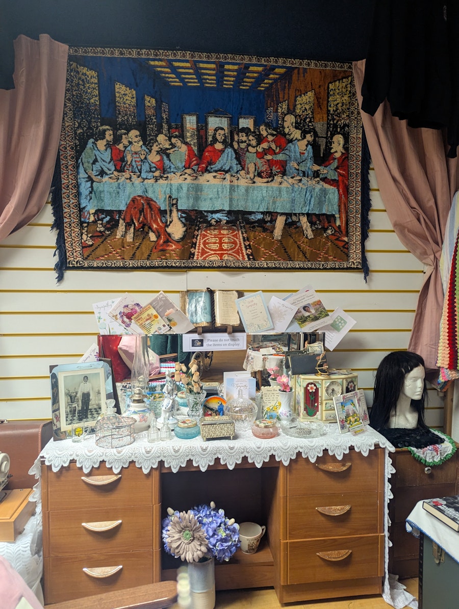 A look inside Windrush Reflection Room, showing a desk, various ornaments and a tapestry.